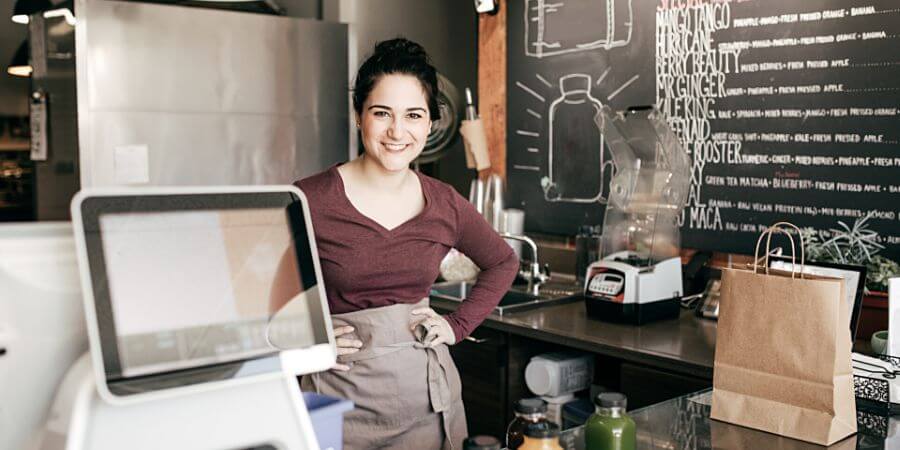 naisyrittäjä istuu tiskin takana